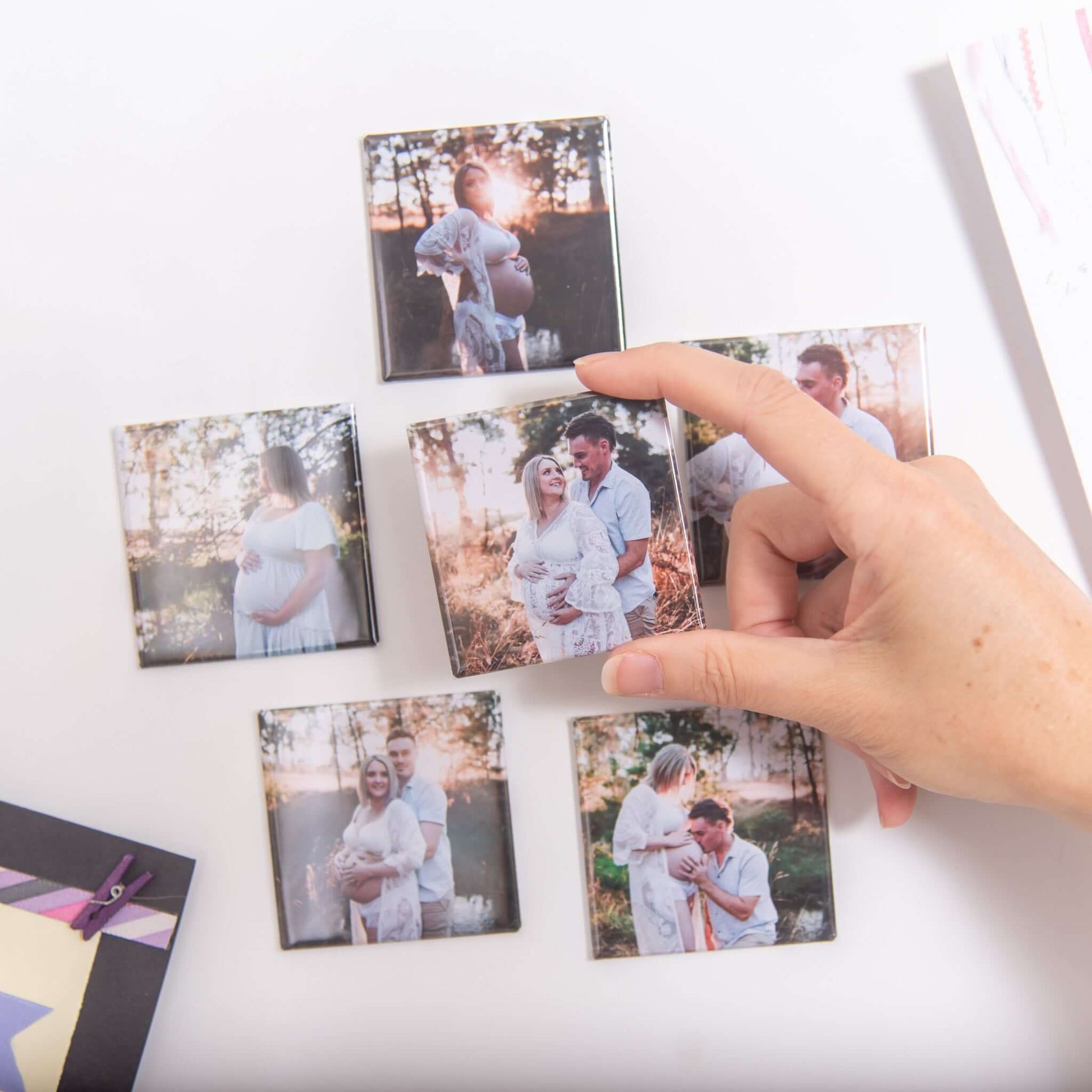 Custom photo magnets: maternity magnets on fridge with hand holding one magnet